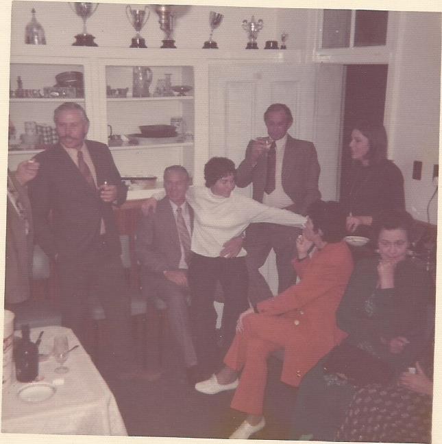 Party gathering in the dining room at 95 Stuart Street Harrismith OFS. Hugo Wessels moustache; Sheila on Wikus de Bruyn's lap (Warden)